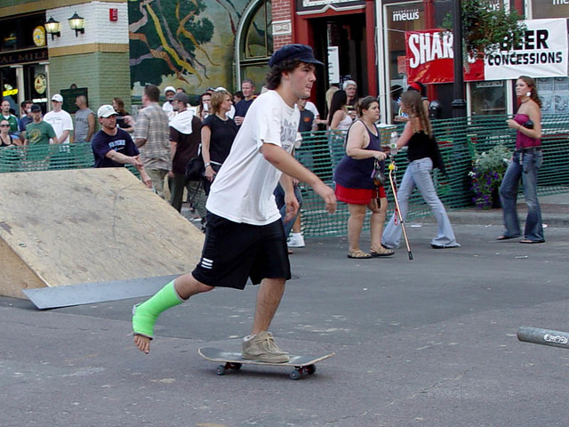 Some hardcore dude skateboarding with a cast on.