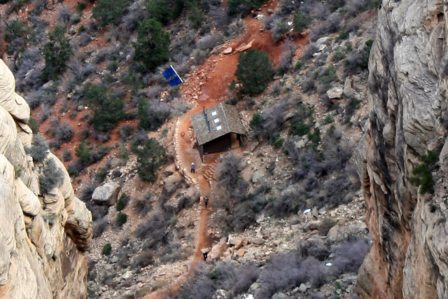 There are a few people and a hut in this pic