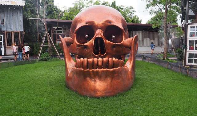 A giant copper skull sculpture with a fierce underbite