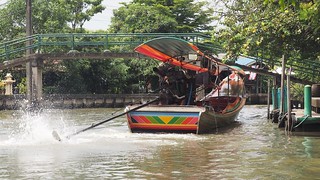 A canal boat driver pivots the engine/prop around to maneuver the boat in the narrow canals
