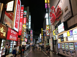 Lots of signs, vending machines, and people, even when it's raining