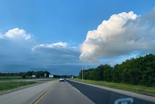 Blue skies above. Wet pavement and gnarly storms to the left.