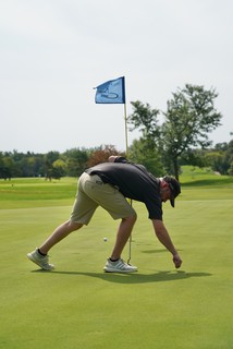 Fixin the ball mark. He damn near backed that thing up right into the hole.