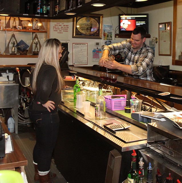 Chuck shows bartender Ashley how to mix and pour shots