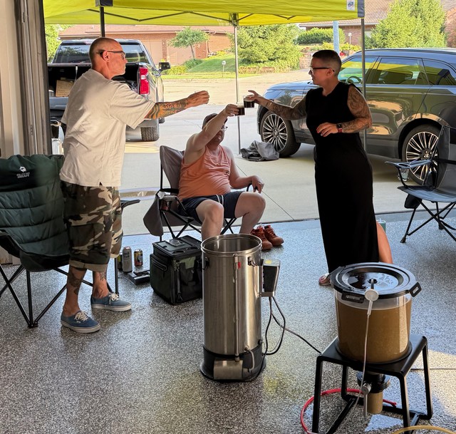 Toasting a successful brew day with a taste of the last batch of homebrew