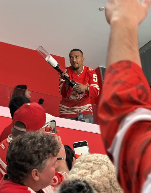 Amon-Ra St Brown shootin out t-shirts from the suite behind me