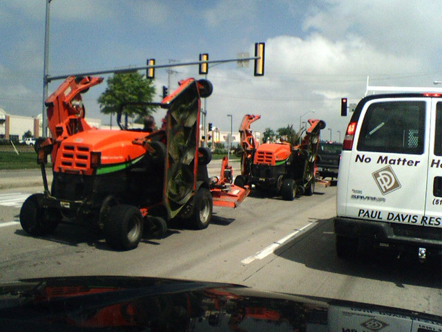 Some big lawn mowers on the street