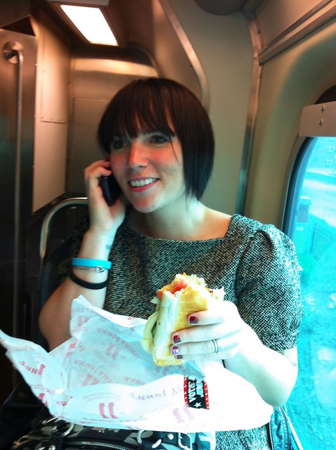 Having a deli sandwich and taking birthday calls on the train.