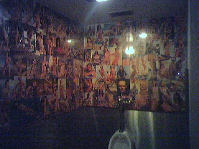 Tons of girls on the wall in the Angry Dog Bathroom