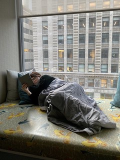 We walk into the hotel room, Kari discovers the window seat, says, “yesssss” and jumps right up there with her book.