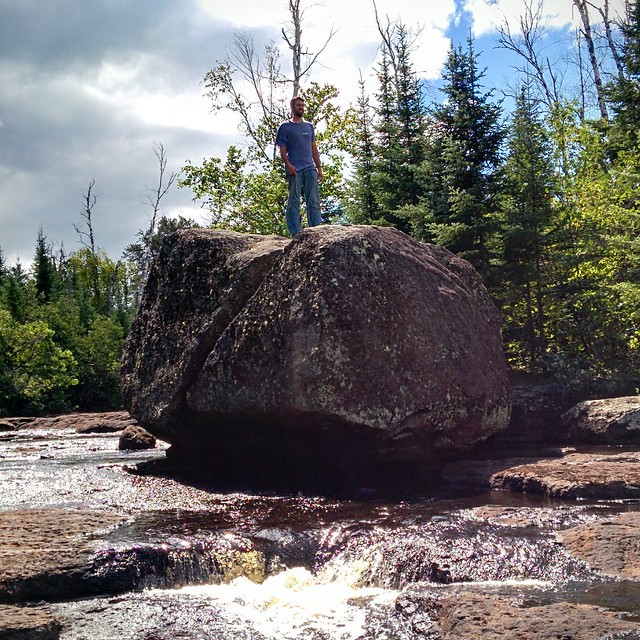Josh climbs the boulder