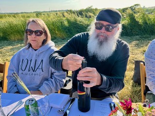 Opening up a bottle of wine in the field