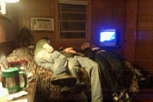 3 men on a bed Photo by Tia O'Brien