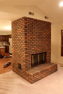 The bohemoth fireplace in between the kitchen and living room