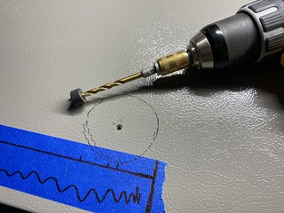 Just piercing the skin before boring all the way through.