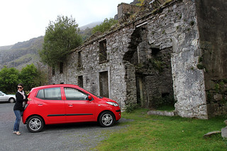 Kari, our car, and some old building at the Gap of Dunloe