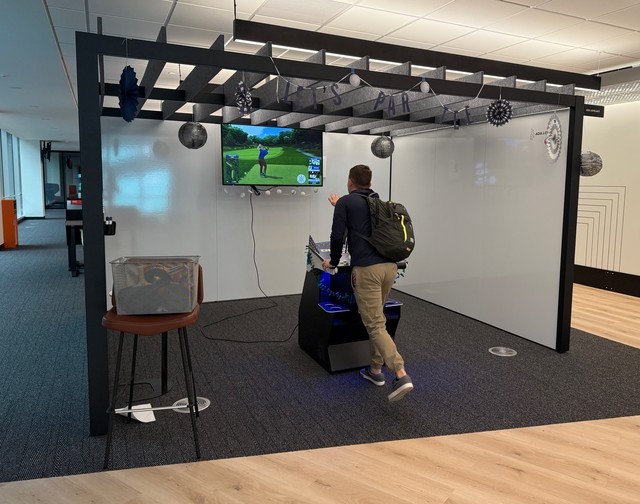 Mark takes a quick swing at the Golden Tee in the office