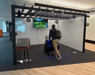 Travel - Mark takes a quick swing at the Golden Tee in the office