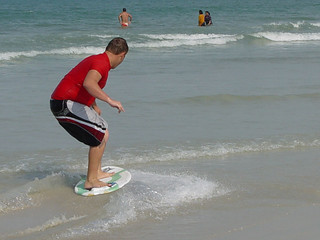 Some dude skimboarding