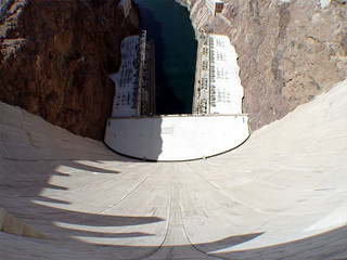 Looking down at the power plants from the middle of the dam.  There are vehicles on the insides -...