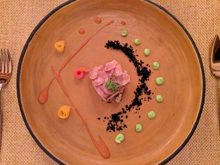 Mahi Mahi filet with quequisque scales. Avacado emulsion, baby corns, rolled pepper slices, and that caviar looking stuff is somehow black olives.