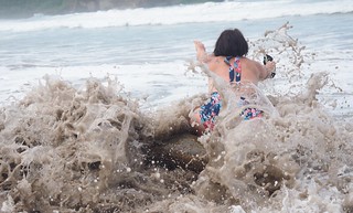 A wave knocks a log seat right out from under Kari, lol