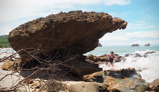A giant lava rock - with Kari getting sprayed by some crashing waves