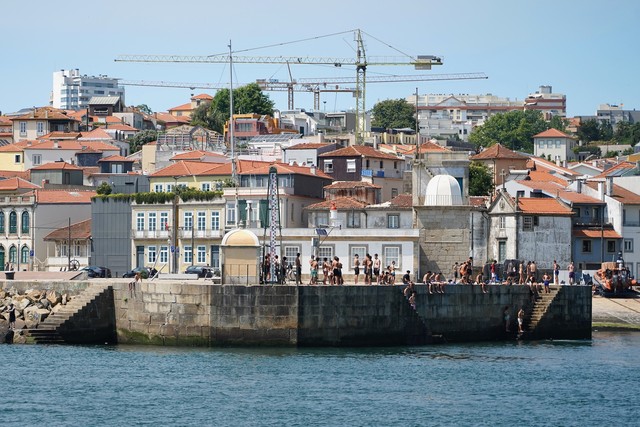 Foz kids hang and jump off the wall into the Douro