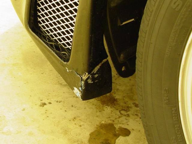 The Driver's Side Front Bumper - Backed over the corner of a curb in the winter