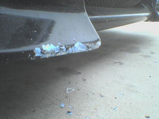 Broken - Mechanic hit a curb with my car - notice the fiberglass chips on the ground