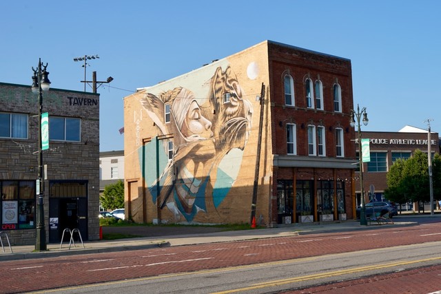 A cool mural between a a tavern and the police athletic league