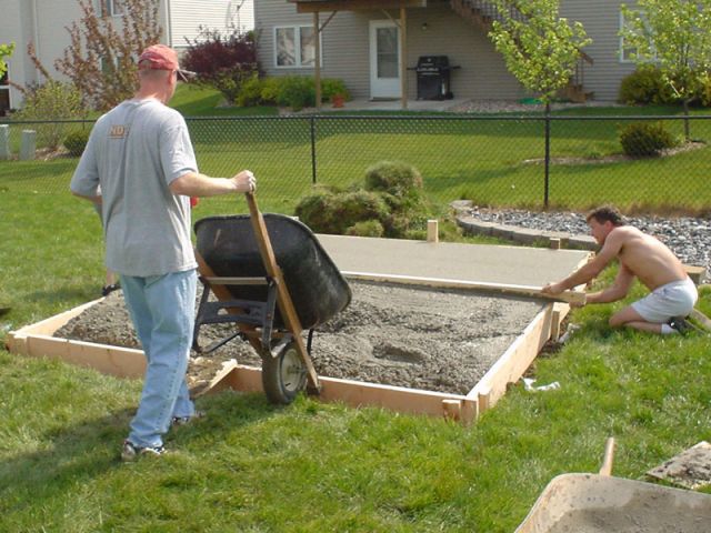 Mike Kock dumping cement while my dad and I level off the slab