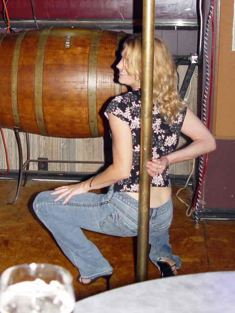 A stripper pole in a karaoke bar... that gets used.