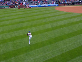 Baseball - Jake Arrieta, warming up by throwing pitches clear across the outfield.